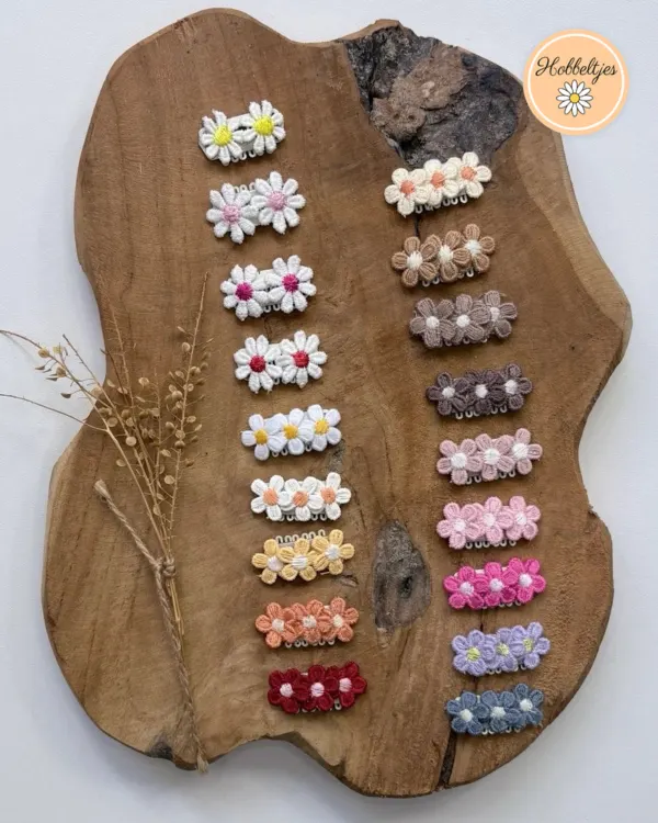 Twee rijen mini antislip haarclipjes met gehaakte bloemetjes in wit, bruin, roze, oranje en blauw