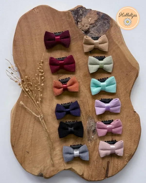 Twee rijen mini antislip haarclipjes Velvy Bows met geribde strikjes in onder meer bordeaux, oranje, mint en roze