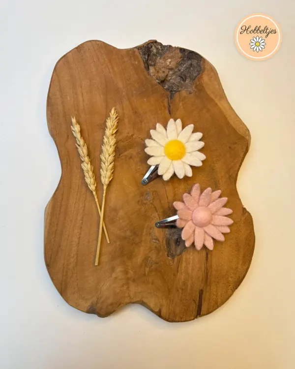 Twee haarspeldjes met een grote vilten bloem in wit met geel hart en in roze